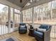 Screened-in porch featuring wood floors and ceiling, two blue chairs with pillows, and views of the forest at 696 The Parks Dr, Pittsboro, NC 27312