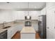 Modern kitchen with stainless appliances, ample storage in white cabinets, granite countertops, and pendant lighting at 711 Keystone Park Dr # 51, Morrisville, NC 27560