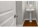 Stylish half bathroom with a pedestal sink, wood floors, and a classic design for guests at 711 Keystone Park Dr # 51, Morrisville, NC 27560