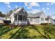 Angle view of the rear exterior of the home and a screened-in porch from the backyard at 818 Cabin Creek, Pittsboro, NC 27312