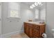 Bathroom vanity with warm wood cabinetry, stone countertop, and a large mirror at 818 Cabin Creek, Pittsboro, NC 27312