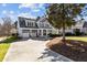 Stunning home showcasing a large driveway, attached garage, and a covered front porch at 818 Cabin Creek, Pittsboro, NC 27312