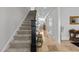 Hallway with staircase, showcasing neutral walls, tile flooring, and a view into the living area at 818 Cabin Creek, Pittsboro, NC 27312