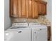Functional laundry room with side-by-side washer and dryer and upper cabinets at 818 Cabin Creek, Pittsboro, NC 27312