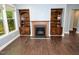 Living room with hardwood floors, fireplace with built-in shelving at 905 Maynard Creek Ct, Cary, NC 27513
