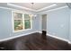 Bright living room with hardwood floors, tray ceiling, and fresh paint at 905 Maynard Creek Ct, Cary, NC 27513