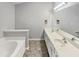Bathroom featuring dual sinks, a large mirror, and a soaking tub at 1009 Bittbourg Ln, Wendell, NC 27591