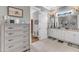 Bright bathroom featuring a double vanity with white cabinets and a large, well-lit mirror at 1100 Kingwood Dr, Raleigh, NC 27609