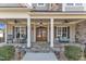 Inviting front porch with stone flooring, rocking chairs, and craftsman-style front door at 1100 Kingwood Dr, Raleigh, NC 27609