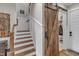 Hallway with wooden stairs and a decorative barn door leading to a closet at 1100 Kingwood Dr, Raleigh, NC 27609