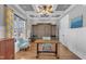 Home Office featuring custom cabinetry, coffered ceilings, and large windows at 1100 Kingwood Dr, Raleigh, NC 27609