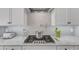 Gourmet kitchen featuring granite counters, custom cabinets, modern backsplash, and a pot filler over the stove at 1100 Kingwood Dr, Raleigh, NC 27609