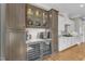 Contemporary kitchen with a wet bar featuring a built-in wine refrigerator and custom glass-front cabinets at 1100 Kingwood Dr, Raleigh, NC 27609