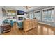Open-concept living room with hardwood floors, large windows, and a brick fireplace at 1100 Kingwood Dr, Raleigh, NC 27609