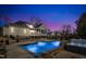 Relaxing pool with ambient lighting, alongside a cozy hot tub and outdoor living space at twilight at 1100 Kingwood Dr, Raleigh, NC 27609