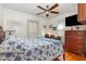Bright bedroom featuring a ceiling fan, wooden floors, and a cozy bed with a blue floral pattern bedding at 114 Evelyn Dr, Knightdale, NC 27545