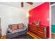 A bedroom space with a gray sofa, red accent wall, and wooden dresser at 114 Evelyn Dr, Knightdale, NC 27545