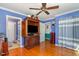 Spacious bedroom with hardwood floors, featuring a ceiling fan and TV armoire at 114 Evelyn Dr, Knightdale, NC 27545