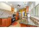 A well-lit kitchen featuring wooden cabinets, granite countertops, and mosaic tile backsplash at 114 Evelyn Dr, Knightdale, NC 27545