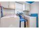 Functional laundry room with modern washer and dryer units and ample storage cabinets at 114 Evelyn Dr, Knightdale, NC 27545
