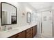 Bright bathroom featuring double sinks, and a glass shower with a walk-in closet at 140 Big Barn Dr, Wendell, NC 27591