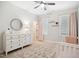 Bright bedroom featuring a white dresser, round mirror, ceiling fan, and patterned rug at 140 Big Barn Dr, Wendell, NC 27591