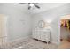 Bright bedroom featuring a white dresser, round mirror, ceiling fan, rug and walk-in closet at 140 Big Barn Dr, Wendell, NC 27591