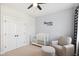 Neutral bedroom featuring a crib, chair, ottoman, ceiling fan, and closet at 140 Big Barn Dr, Wendell, NC 27591