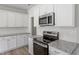 Modern kitchen featuring white cabinets, stainless steel appliances, and granite countertops at 156 Fideaux Blvd # 248, Raleigh, NC 27603