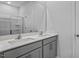 Bathroom showcasing double sinks, quartz countertops, gray cabinets, and a large mirror at 2241 Horton Park Dr, Apex, NC 27539