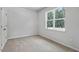 Bright bedroom with carpet flooring and a window offering a view of a wooded area at 2241 Horton Park Dr, Apex, NC 27539