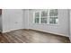 Bright bedroom features hardwood floors, three windows, and a closet with double doors at 2241 Horton Park Dr, Apex, NC 27539
