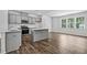 Well-lit kitchen with stainless steel appliances, an island and sleek gray cabinets and hardwood floors at 2241 Horton Park Dr, Apex, NC 27539