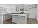 Modern kitchen featuring stainless appliances, an island, sleek gray cabinets and hardwood floors at 2241 Horton Park Dr, Apex, NC 27539