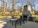 Outdoor patio with fireplace, seating area, and backyard featuring lush trees at 2511 Pineway Dr, Burlington, NC 27215