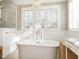 Luxurious bathroom features a freestanding tub, a window with shutters, and a chandelier at 2511 Pineway Dr, Burlington, NC 27215