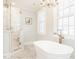Bathroom featuring a freestanding tub, frameless glass shower and transom window with shutter at 2511 Pineway Dr, Burlington, NC 27215
