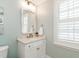 Bathroom featuring custom vanity, gold fixtures, decorative framed mirror and window with shutter at 2511 Pineway Dr, Burlington, NC 27215