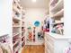 Walk-in closet with custom shelving, cabinet and hardwood flooring at 2511 Pineway Dr, Burlington, NC 27215