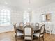 Elegant dining room with a round table, upholstered chairs, large windows, and decorative wallpaper and lighting at 2511 Pineway Dr, Burlington, NC 27215