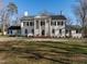 Striking white brick home featuring a symmetrical design with large white columns and a well-manicured front lawn at 2511 Pineway Dr, Burlington, NC 27215