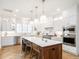 Bright, open kitchen features white cabinets, herringbone floors, a large island, and stainless steel appliances at 2511 Pineway Dr, Burlington, NC 27215