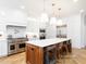 Open kitchen with a large island, wooden barstools, a chef's range, and stainless steel appliances at 2511 Pineway Dr, Burlington, NC 27215