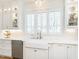 Bright kitchen featuring white cabinets, subway tile backsplash, and a farmhouse sink under the windows at 2511 Pineway Dr, Burlington, NC 27215