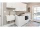 Well-lit laundry room with modern washer and dryer, sink, and stylish tile flooring at 2511 Pineway Dr, Burlington, NC 27215