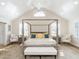 Spacious main bedroom boasting a vaulted ceiling, four-poster bed, sitting area, and bright natural light at 2511 Pineway Dr, Burlington, NC 27215