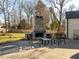 Outdoor patio featuring a stone fireplace and seating area, perfect for entertaining in a serene backyard setting at 2511 Pineway Dr, Burlington, NC 27215