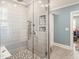 Modern bathroom shower with grey tiles, seamless glass door, and built-in shower caddy at 2511 Pineway Dr, Burlington, NC 27215