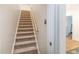 Carpeted stairway leading to the second floor with wood railing and trim at 2511 Pineway Dr, Burlington, NC 27215