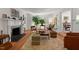 Bright living room with decorative fireplace, hardwood floors, and large windows at 2610 University Dr, Durham, NC 27707